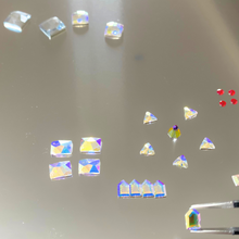 
                          
                            Cargar imagen en el visor de la galería, Colorful crystal-like objects on a reflective surface
                          
                        